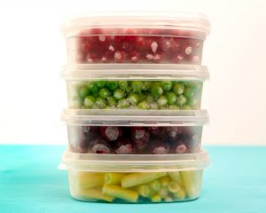 Containers of frozen vegetables stacked on top of each other.