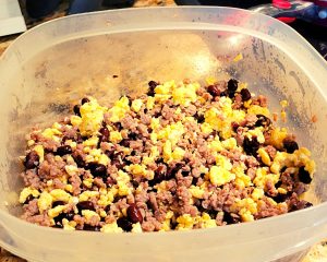 Breakfast sausage, black beans, and eggs mixed in a bowl.