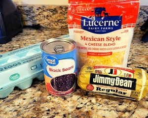 Ingredients for breakfast burrito bowl - eggs, black beans, breakfast sausage, cheese