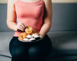 woman sitting on a couch eating donuts